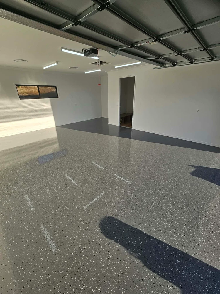Light grey flake epoxy garage flooring with a smooth, glossy finish by Chad's Epoxy Flooring.