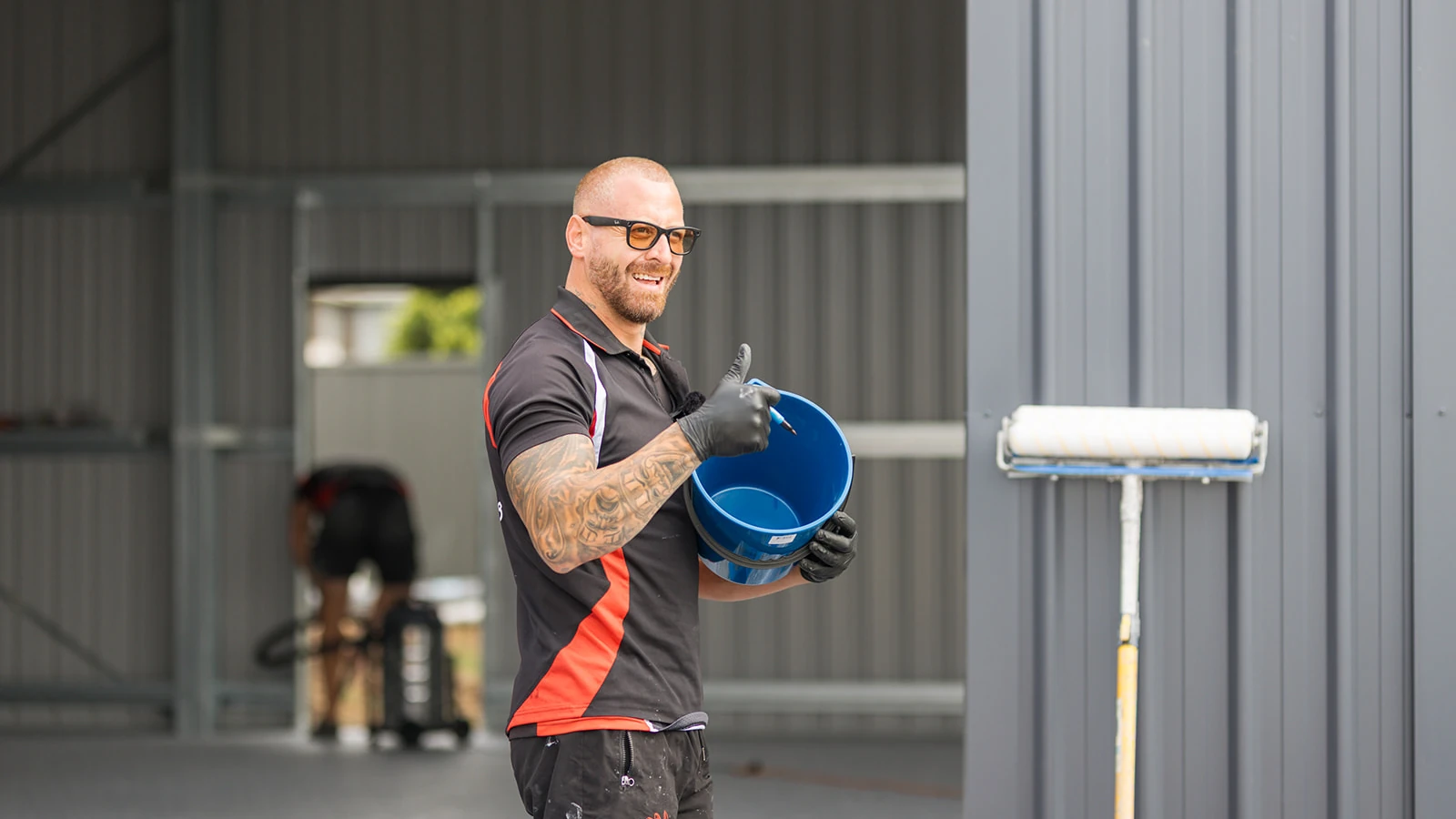 Smiling Chad's Epoxy installer giving a thumbs up with a mixing bucket