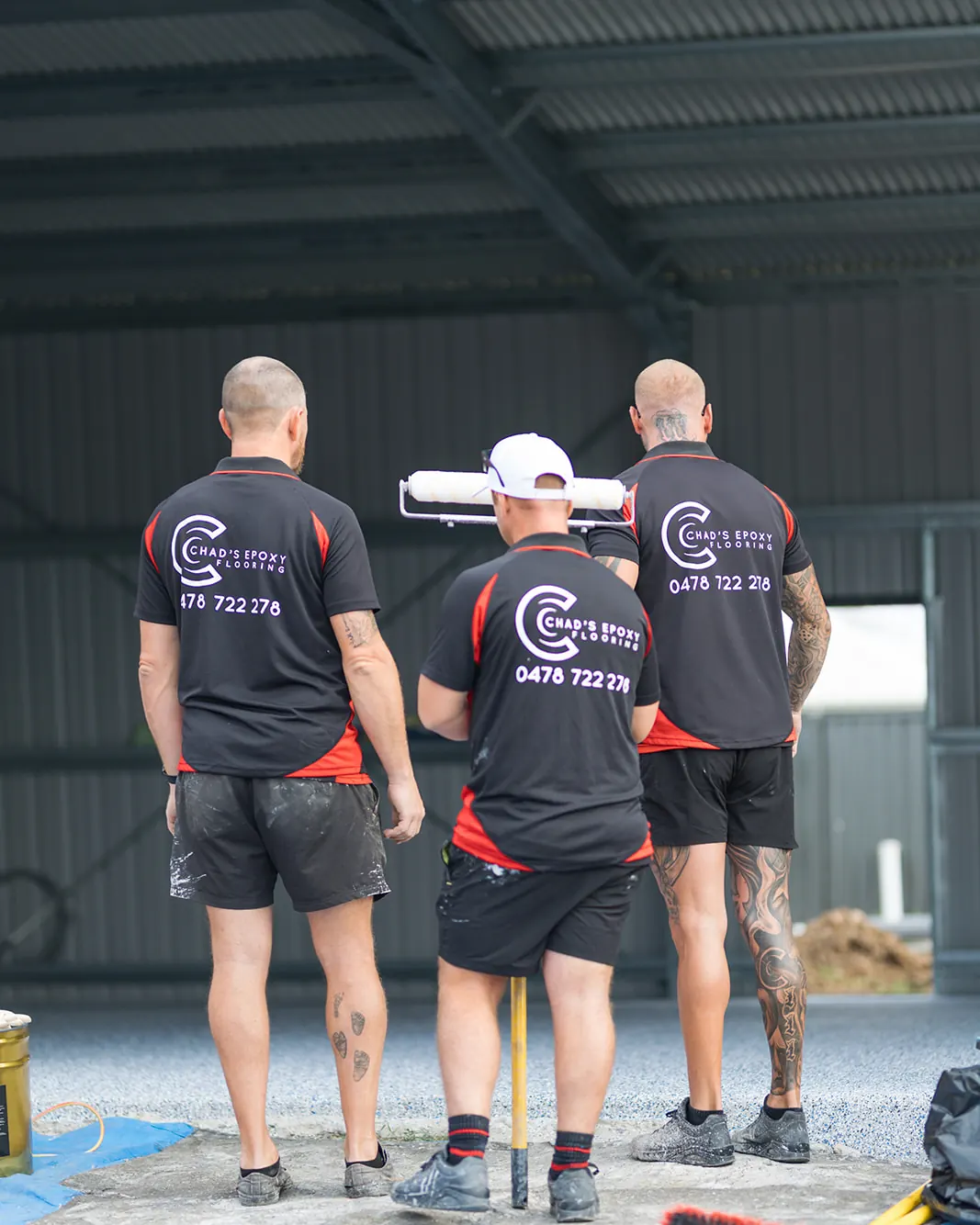 Chad's Epoxy Flooring team inspecting a steel shed floor before an epoxy flake install in Marburg
