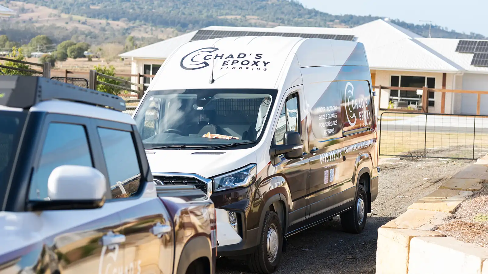 Chad's Epoxy Flooring van and ute parked at a Marburg shed flooring job