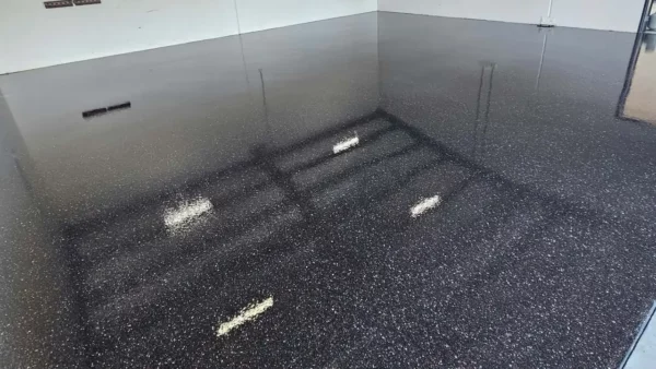 Dark grey flake garage floor with light falling through the open door