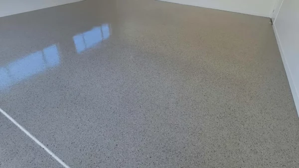 Smooth grey finished garage floor beneath an open roller door