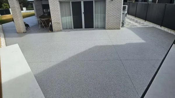 Grey flake floor across an outdoor courtyard beside a two-storey home