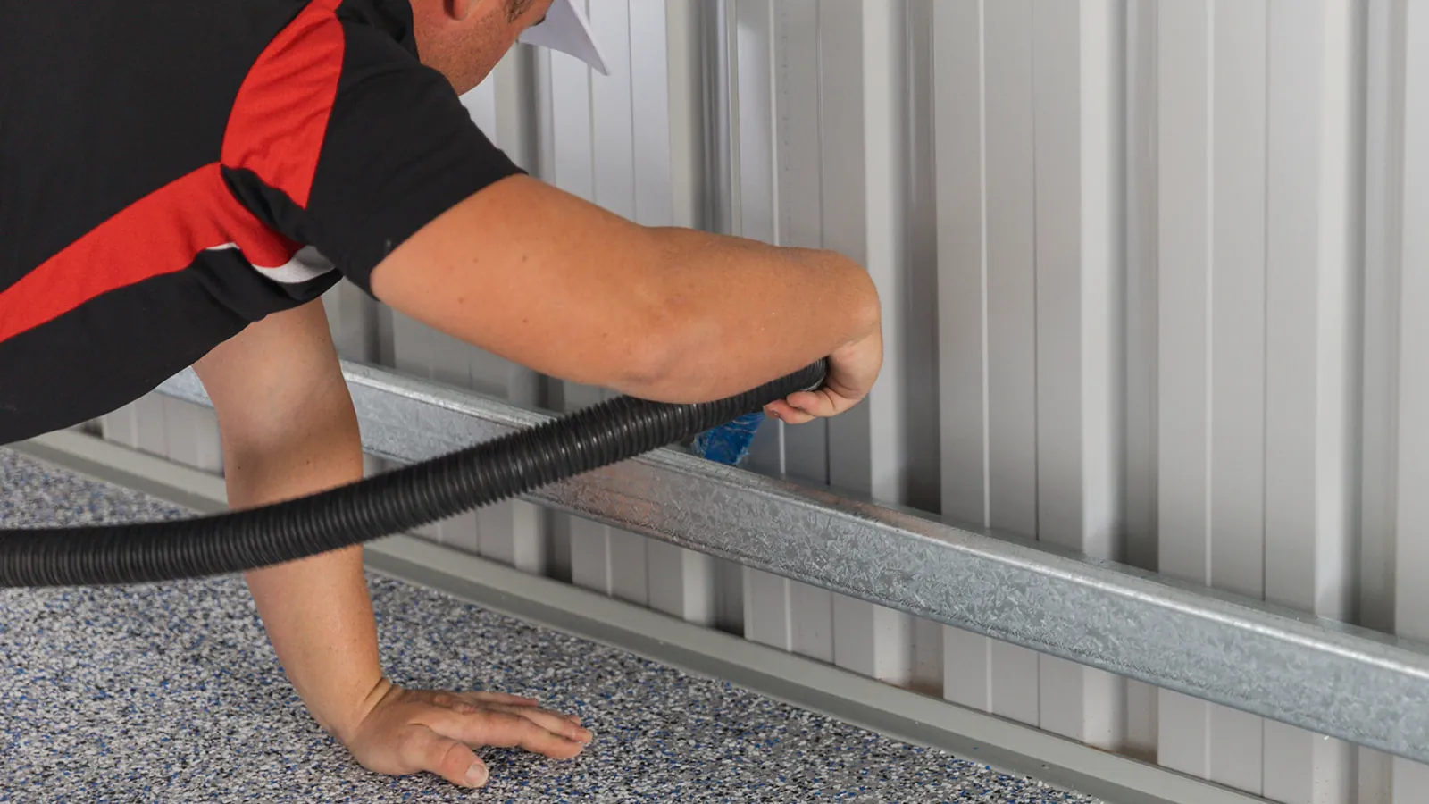 Close-up of vacuum cleaning along the edge of a flake epoxy floor
